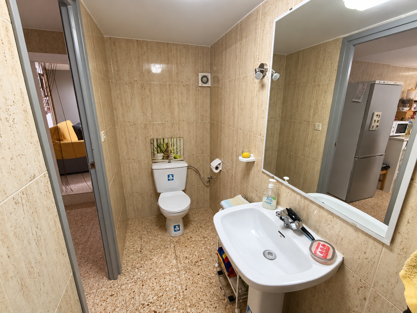 Baño beige ordenado con espejo y lavabo